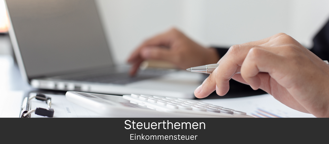 Eine Hand hält einen Stift und tippt auf einem Taschenrechner, während im Hintergrund ein Laptop zu sehen ist. Text: Steuerthemen - Einkommensteuer.